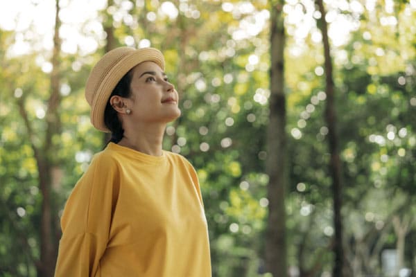 A woman who knows the importance of breaks for family caregivers relaxes at the park.