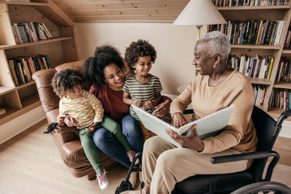 An older woman who is aging with purpose volunteers to read to young children.